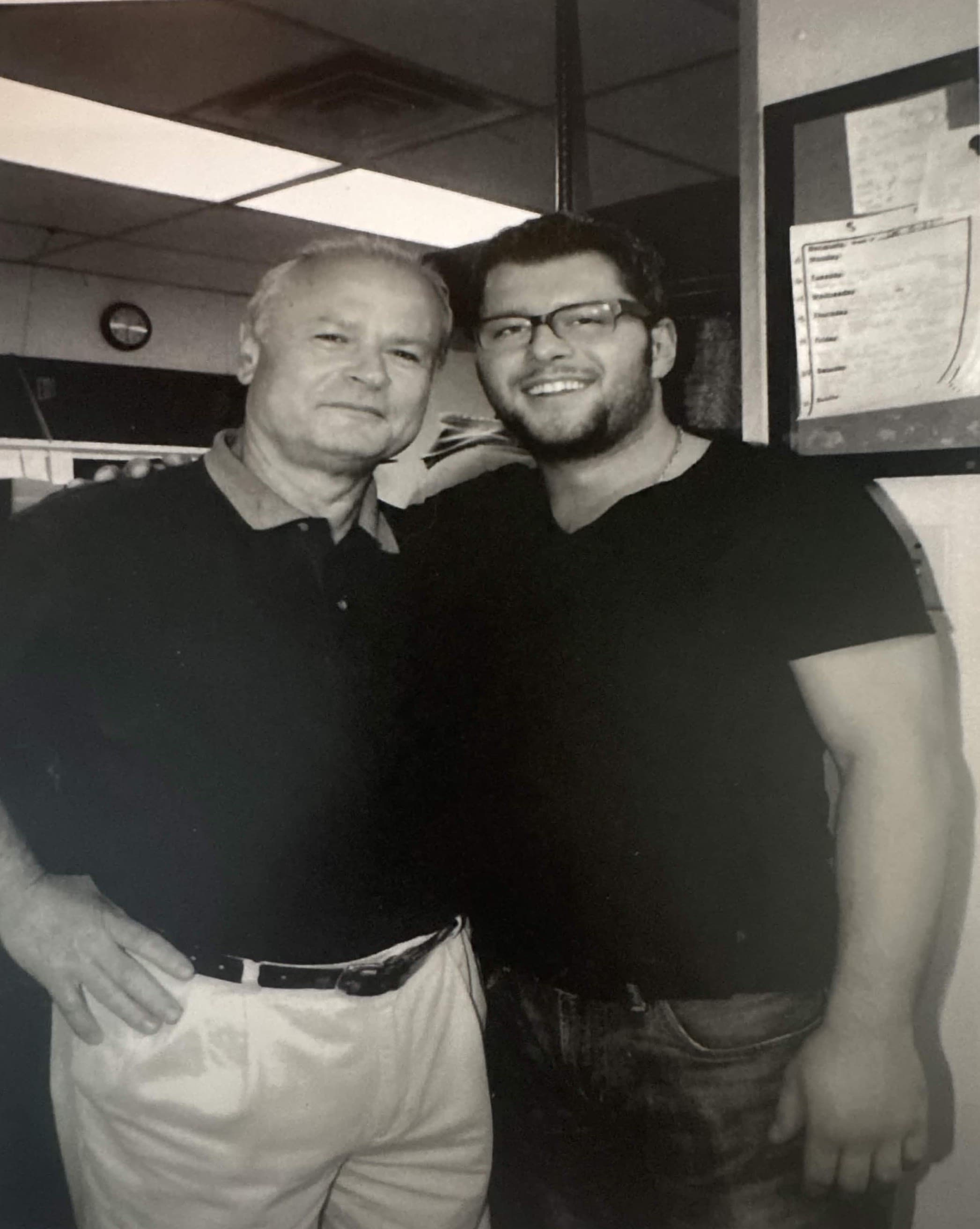 An older man and a younger man together in the Maria's kitchen.