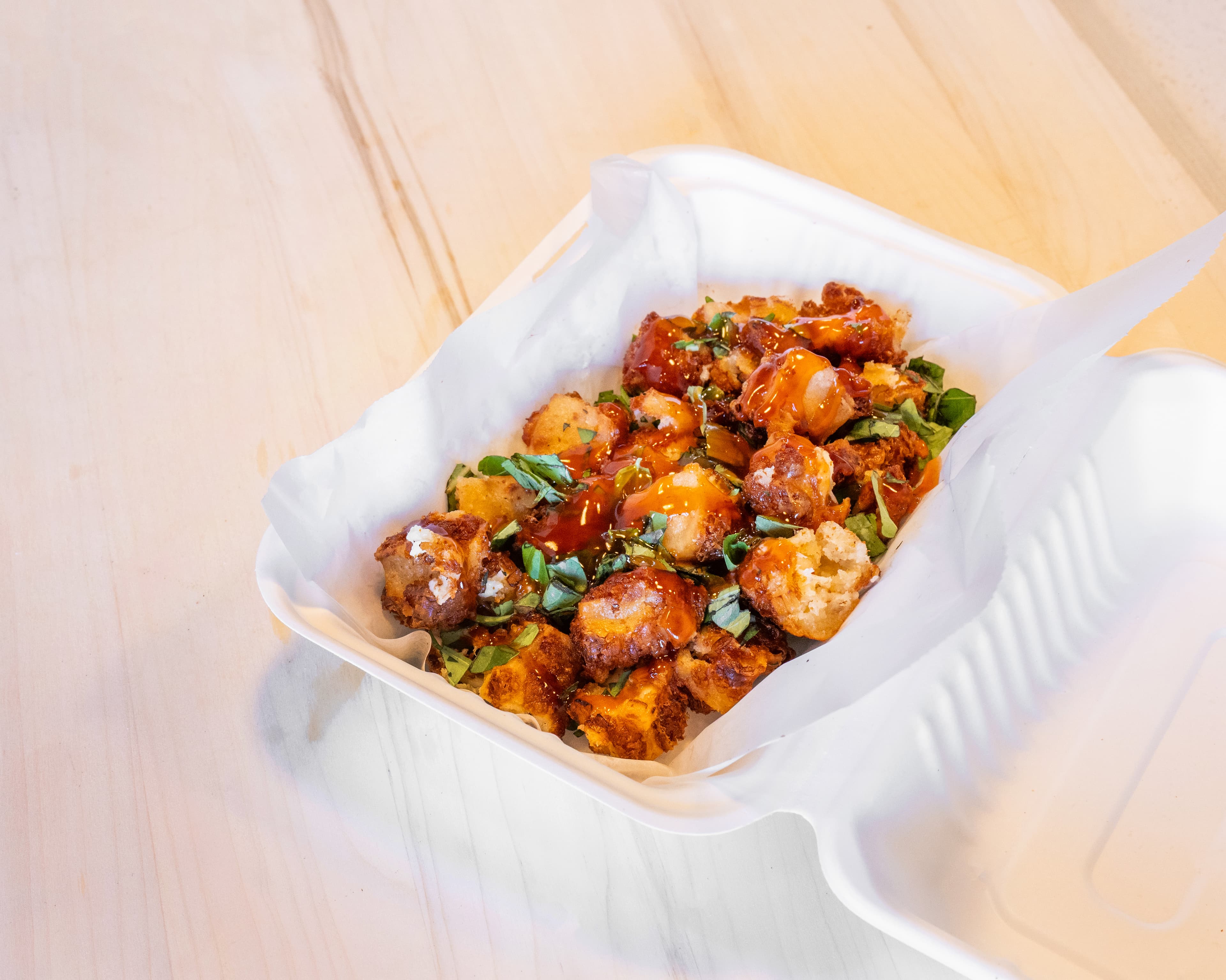 Hot honey cheese curds in a takeout box